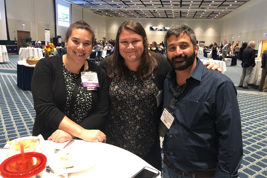 Two women and one man smiling together at a BPA networking reception.