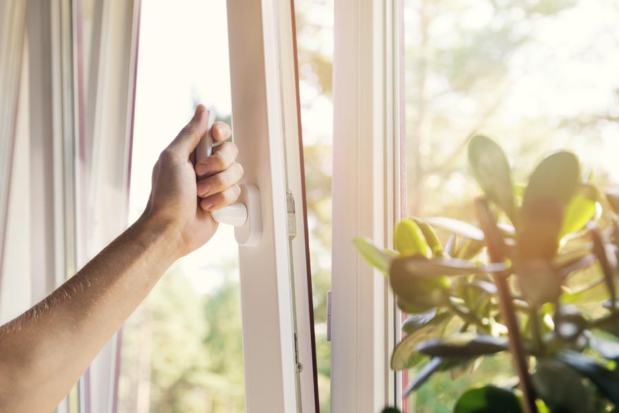 Someone unlocking and opening their home windows.