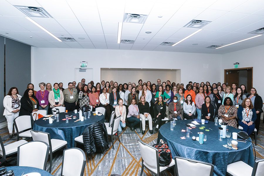 Image of a room full of people gathering for a group photo