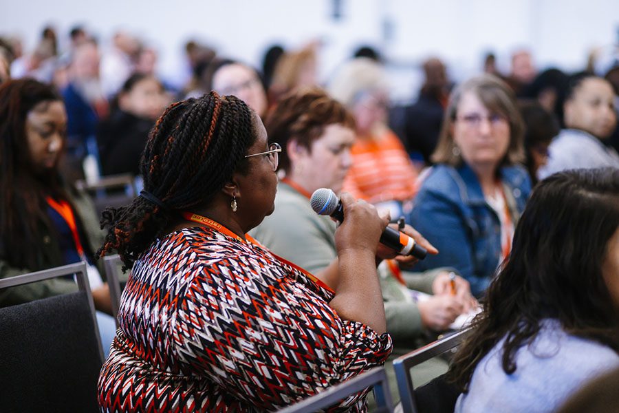 Image of a woman speaking amongst a crowd