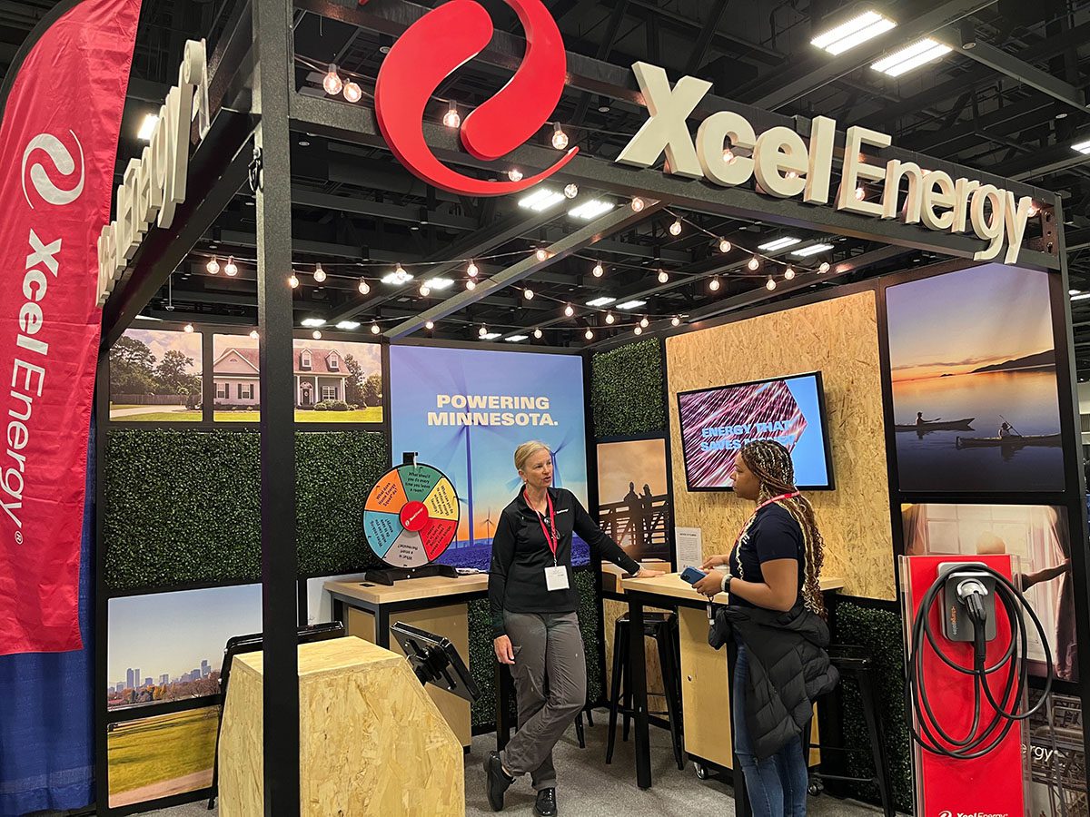 Image of the Xcel Energy booth that features grass and a wheel to spin