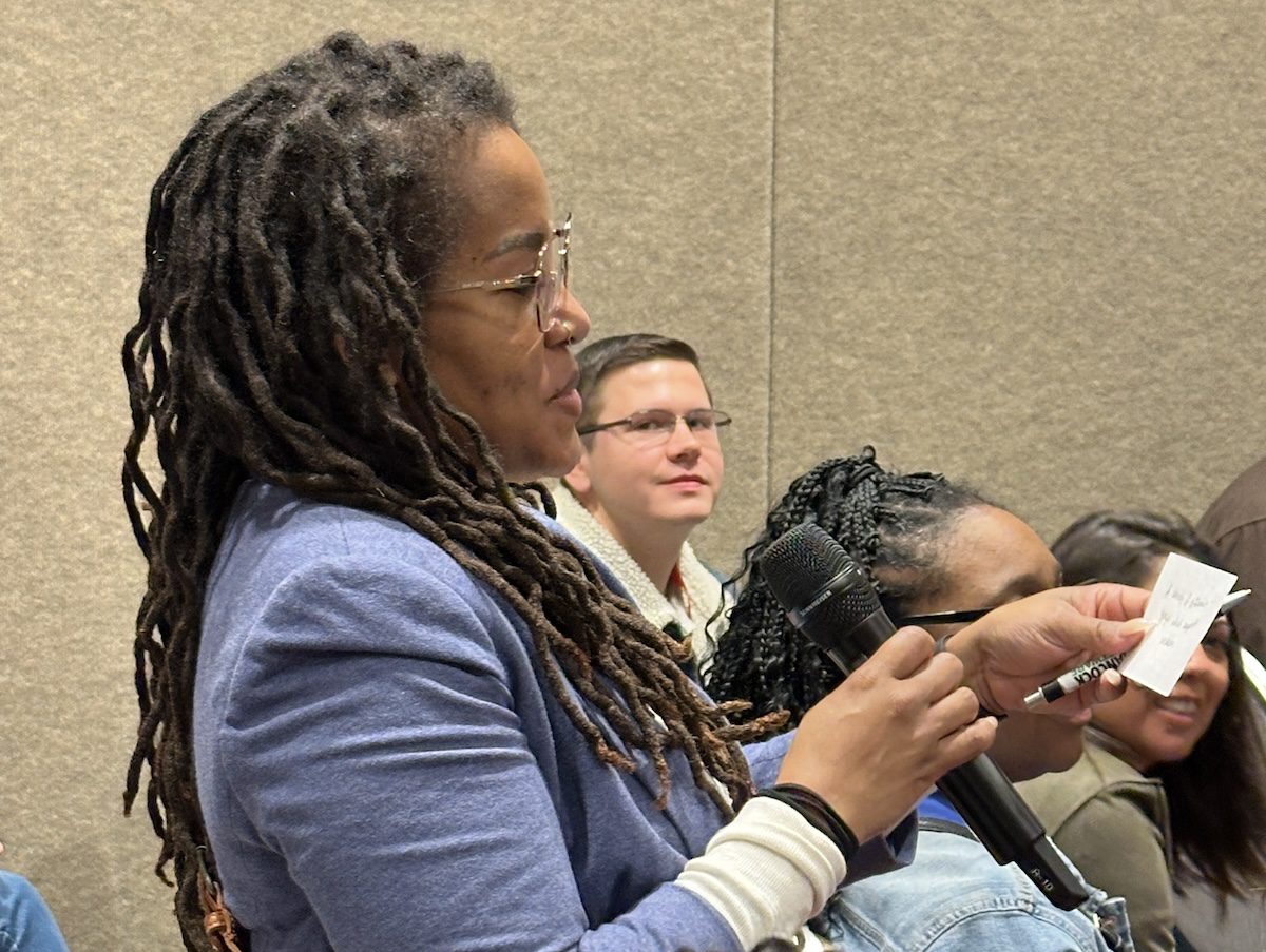 Close up of a women reading from a notecard into a microphone