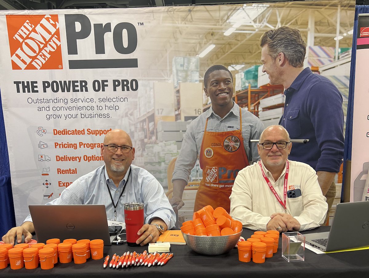 Image of two people at the Home Depot Pro: Power of Pro booth with small orange buckets on the table