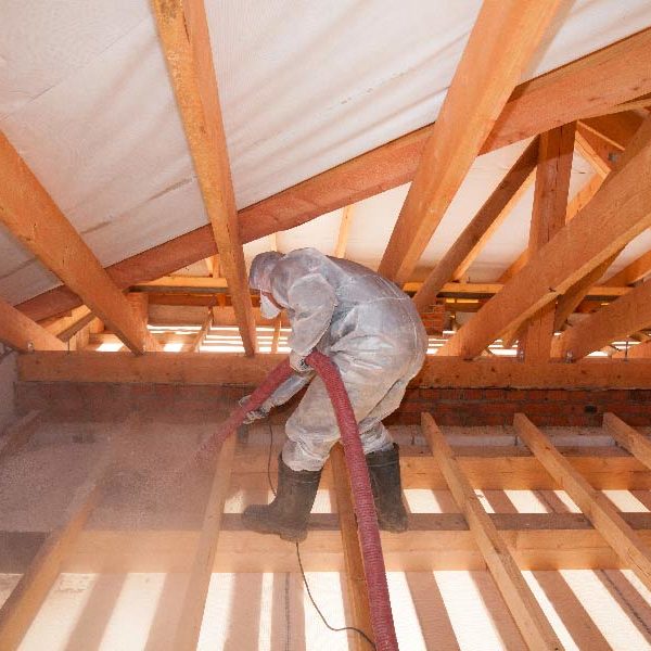 Image of a person spraying insulation in an attic