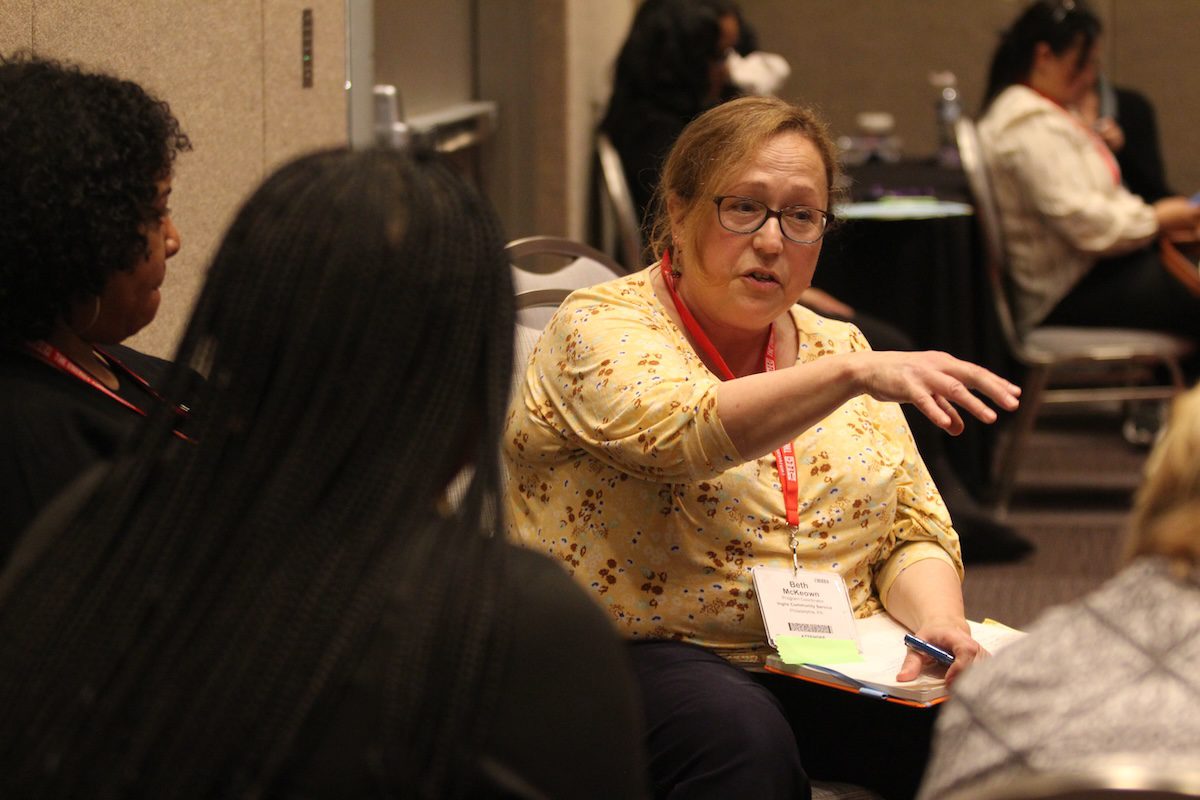 Image of a woman talking to a small group of people