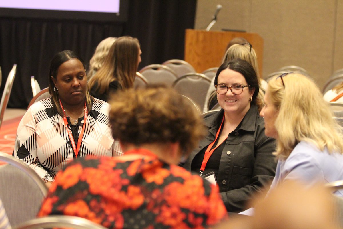 Image of women smiling while listening to a group share in a circle