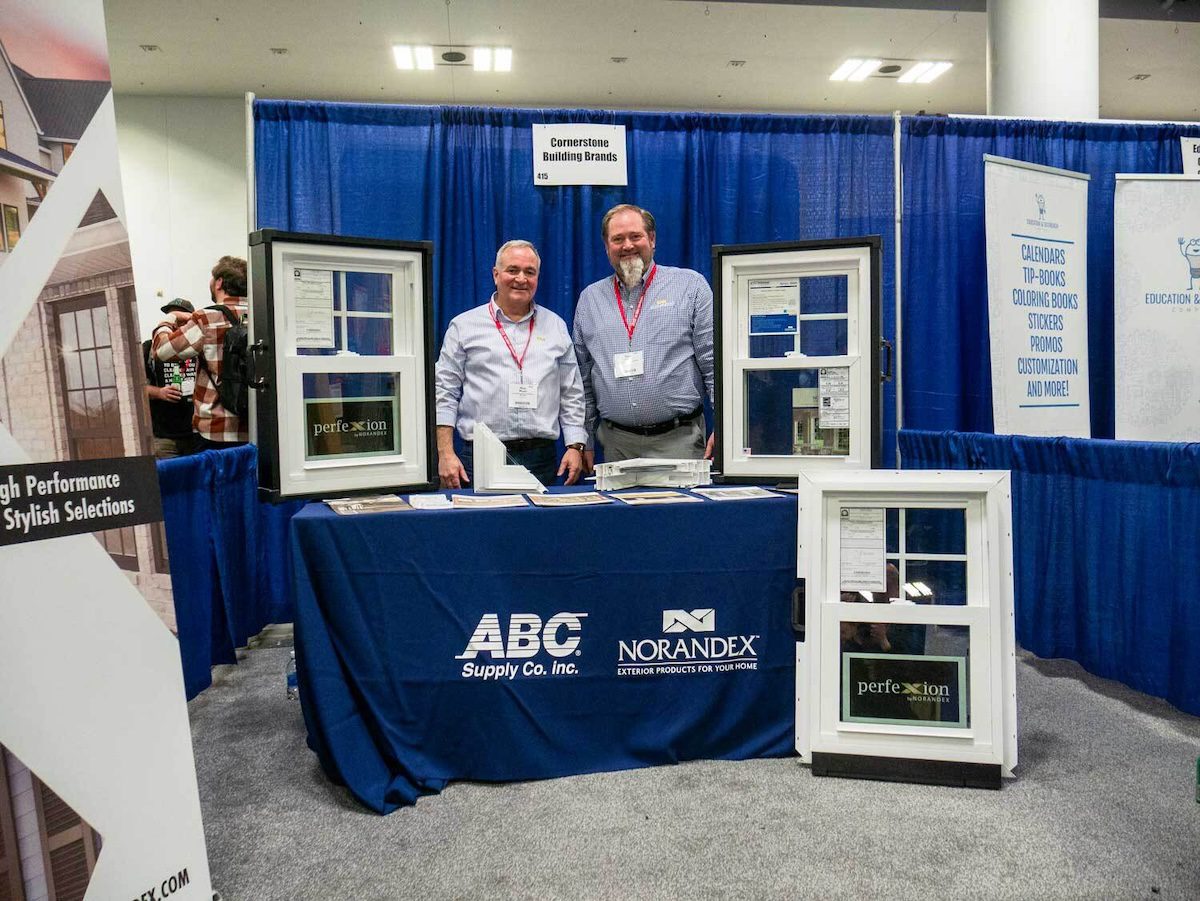 Image of two people at a booth of windows called ABC supply Co, Inc and Norandex Exterior products for your home