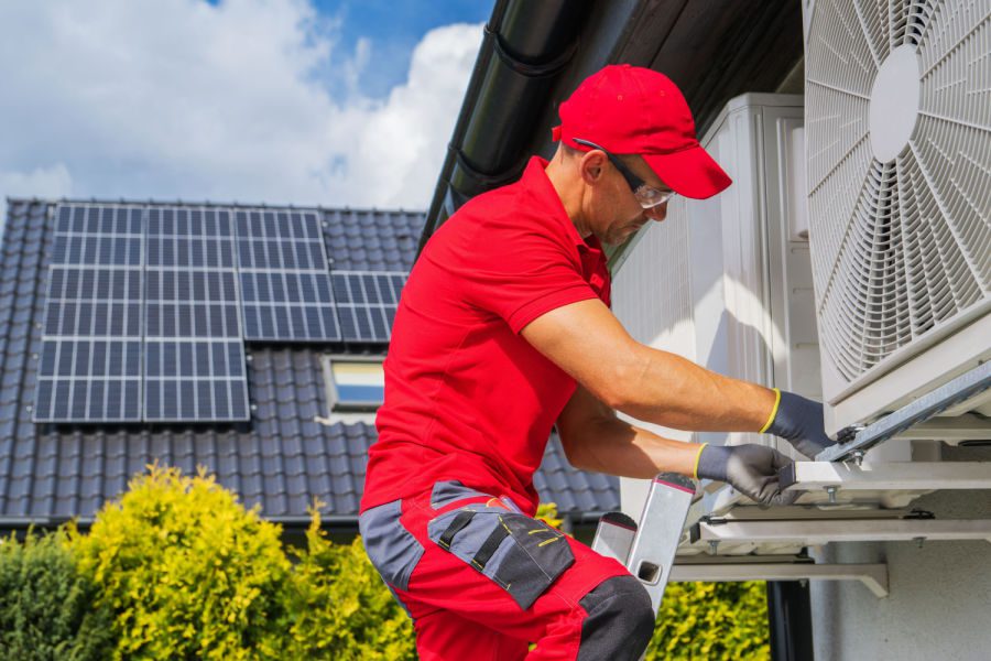 HVAC Worker Performing Heat Pump Maintenance. Device is Transferring Thermal Energy From the Outside Using the Refrigeration Cycle.