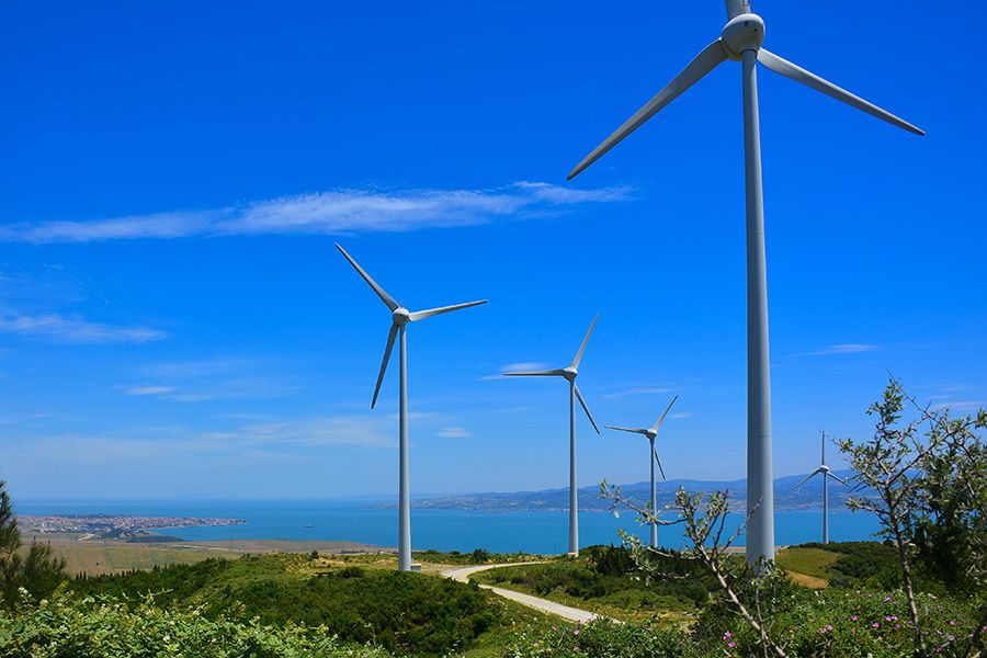 Five modern windmills near a body of water