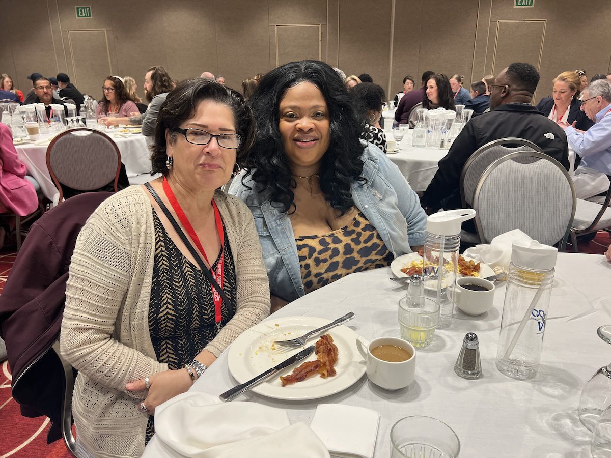 Image of 2 women posing together while having a meal