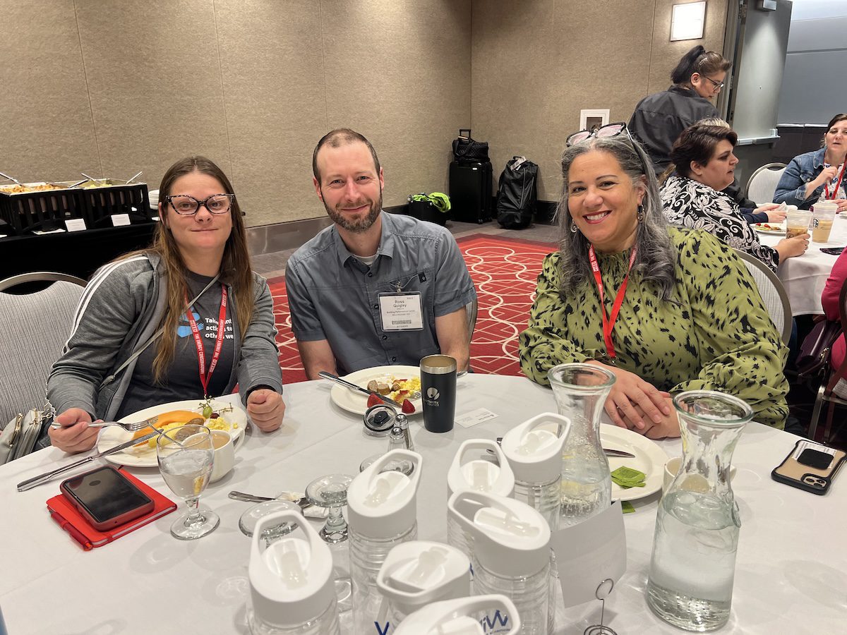 Image of 3 people posing together while having a meal