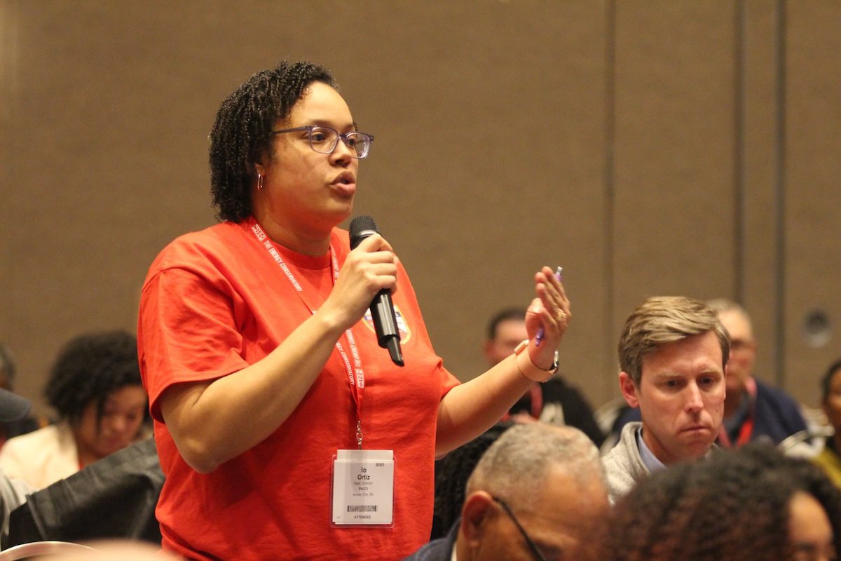 Image of a woman asking a question to a speaker into a microphone