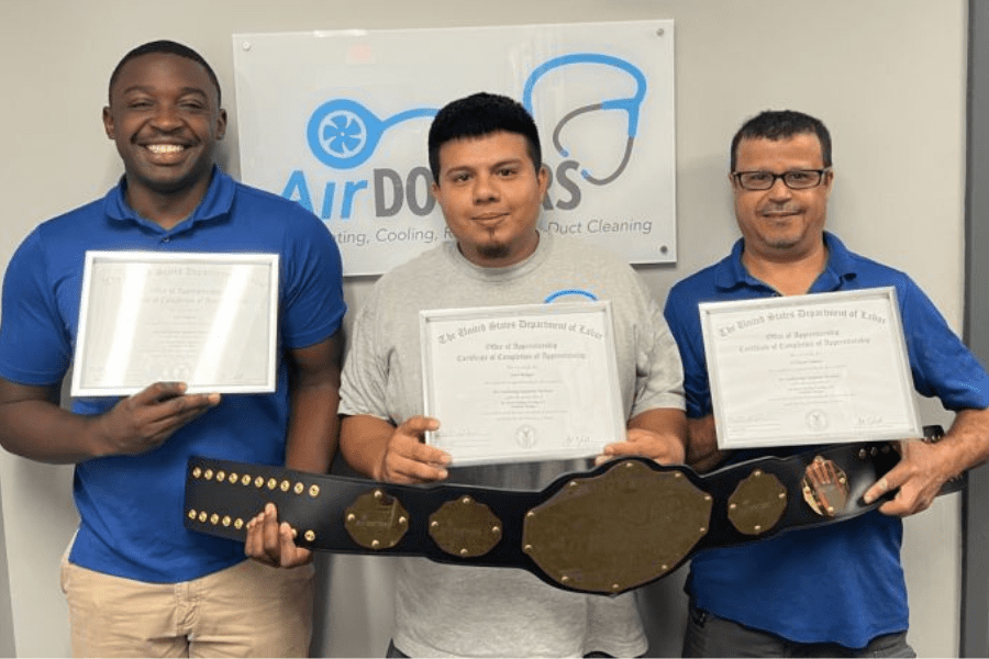 Image of 3 men holding certificates while holding a heavyweight belt