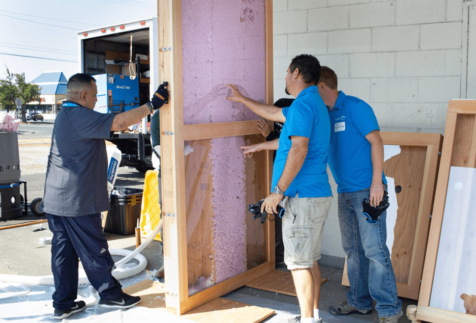 Crew looking at insulation inside wall cavity