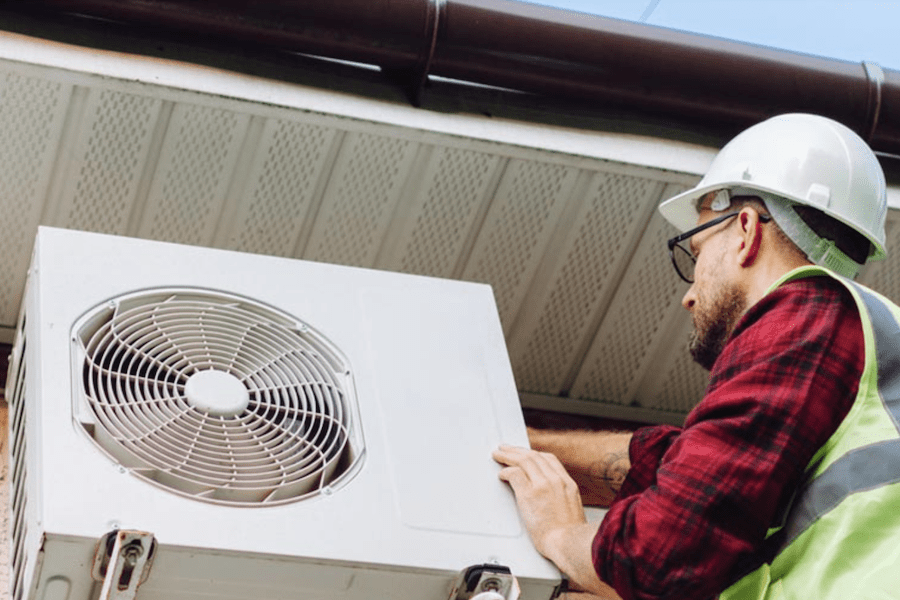 Worker installing a heat pump