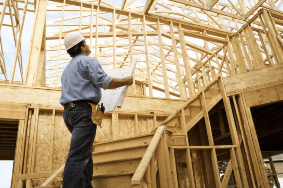 Construction worker inside framed house